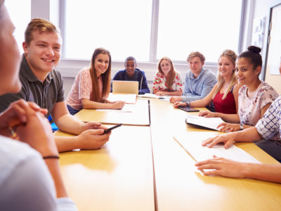 College Students Sitting At Table Having Discussion